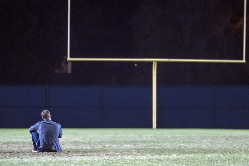 Kevin (Justin Hartley) en pleine réflexion sur le terrain de football.