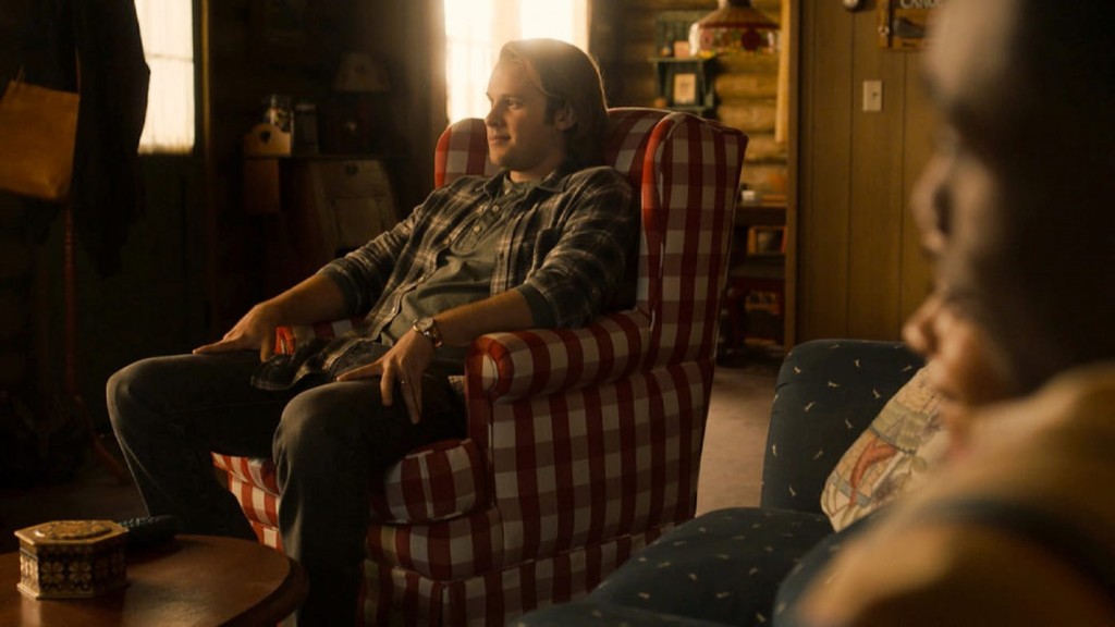 Kevin (Logan Shroyer) assis confortablement au chalet. 