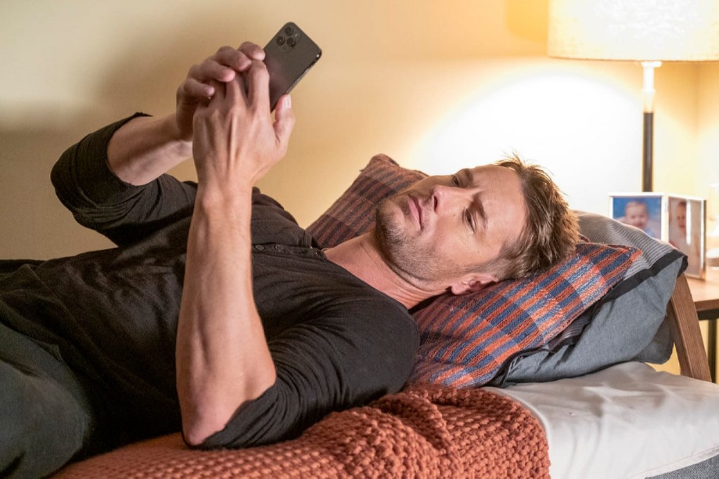 Kevin (Justin Hartley) regarde son téléphone.