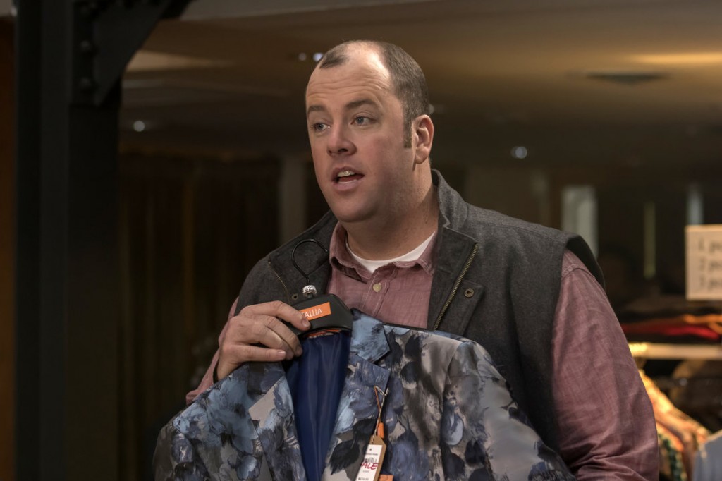 Toby (Chris Sullivan) magasine une veste.